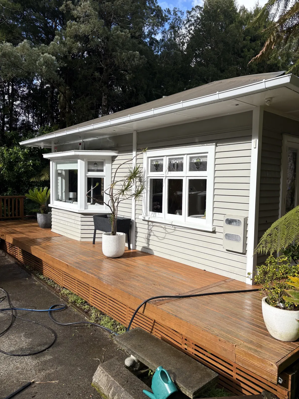 Cleaned timber deck in front of a weatherboard home in West Auckland