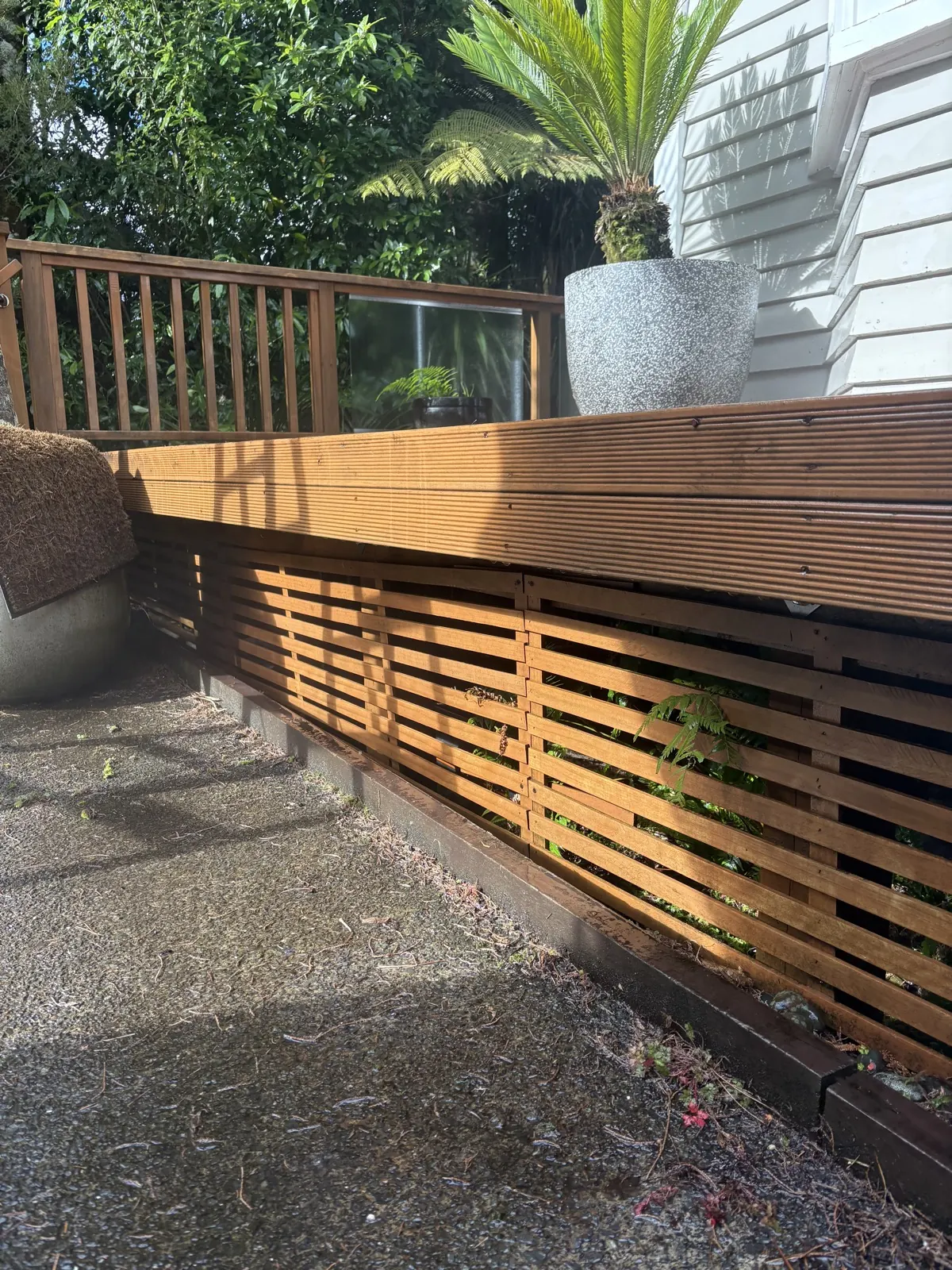 Cleaned timber deck edge and slatted skirting in afternoon sun